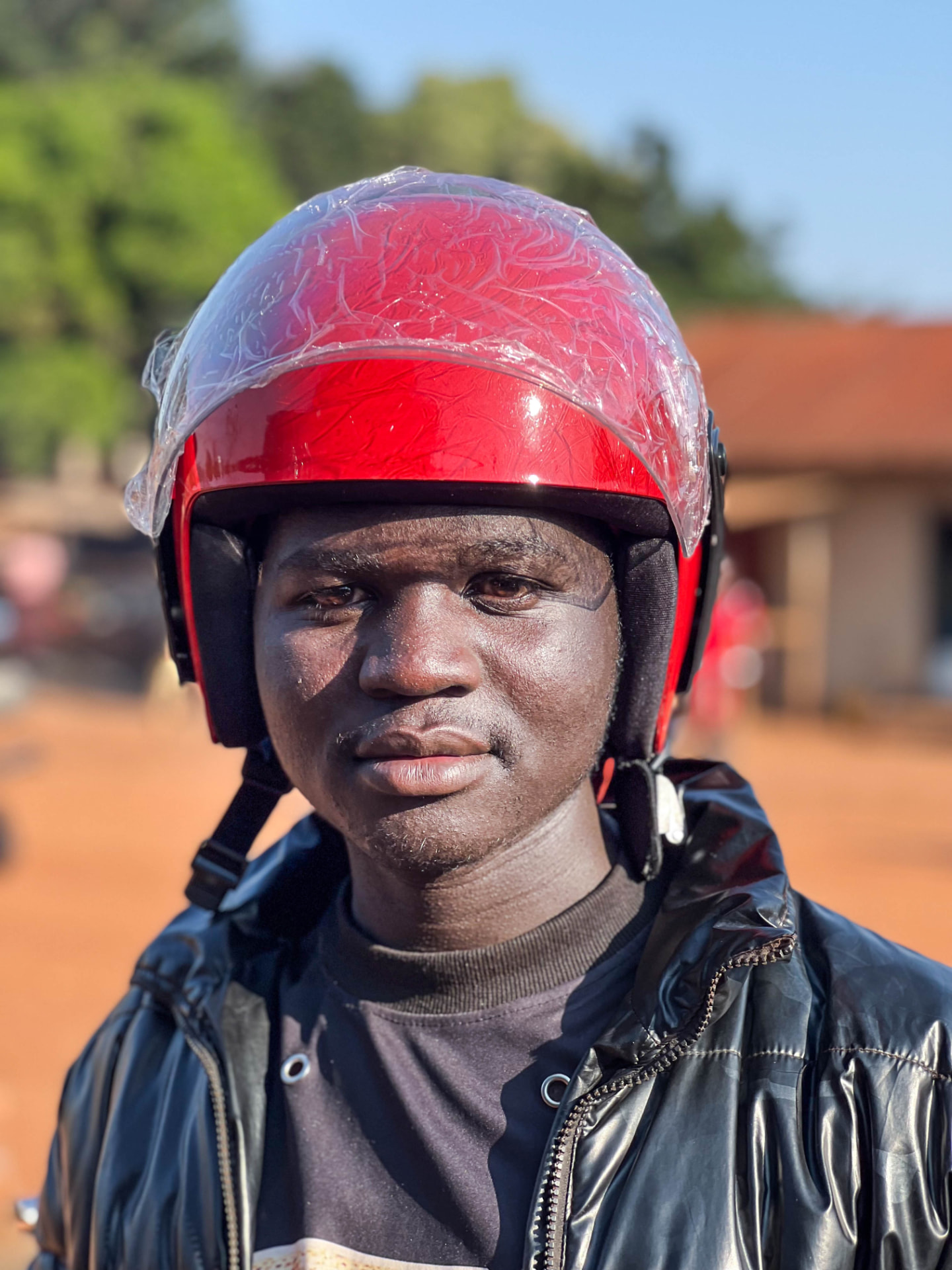 Portrait of a boda-boda rider wearing one of the helmets distributed in the campaign