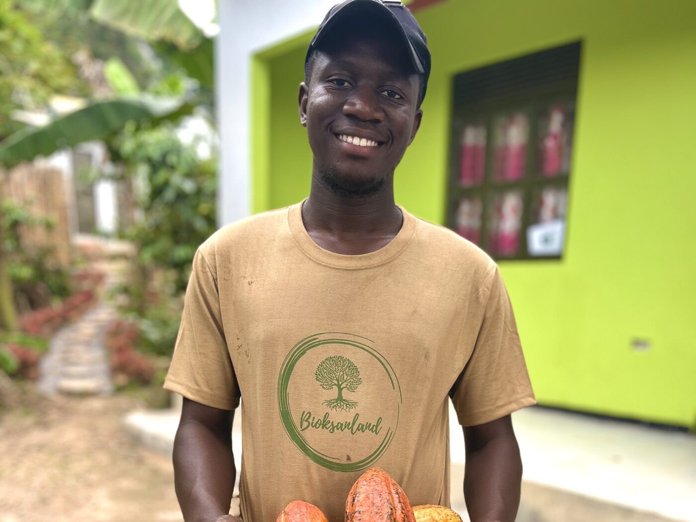 Bioksanland worker holding freshly harvested cacao pods, Uganda